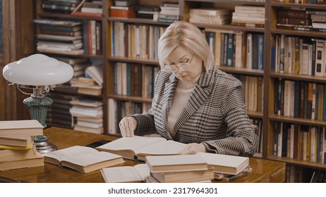 Senior female scientist doing research at the library, reading books, her hobby - Powered by Shutterstock