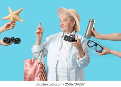 Senior female tourist and hands with travel accessories on blue background - Powered by Shutterstock