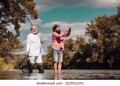 Senior Fisherman In Suit And Bearded Casual Man Fishing With Fishing Rod.