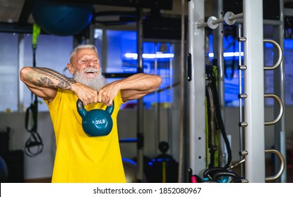 Senior fit man doing kettle bell exercises inside gym - Fit mature male training in wellness club center - Body building and sport healthy lifestyle concept - Powered by Shutterstock