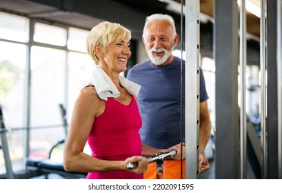 Senior fit man and woman doing exercises in gym to stay healthy - Shutterstock ID 2202091595
