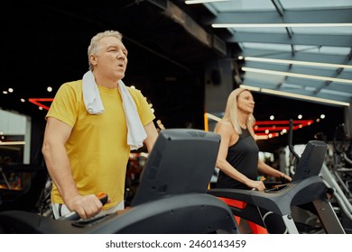 Senior fitness enthusiasts engaged in treadmill session at modern fitness center. Active older couple staying fit with gym workouts. Concept of sport, active seniors in modern life, healthy lifestyle. - Powered by Shutterstock