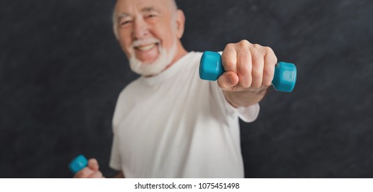 Senior Fitness Man Training With Dumbbells At Gym, Doing Strength Exercise For Biceps, Black Background. Active Lifestyle And Healthcare In Any Age, Copy Space