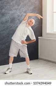 Senior Fitness Man Warmup Stretching Training Indoors. Sporty Mature Guy Makes Aerobics Exercise. Active Lifestyle And Healthcare In Any Age, Copy Space