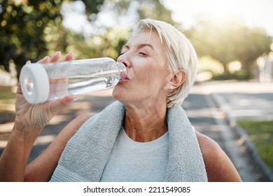 Senior fitness woman drinking water bottle outdoors after training, running workout and exercise in neighborhood street. Thirsty elderly lady runner hydration rest for cardio wellness or marathon jog - Powered by Shutterstock