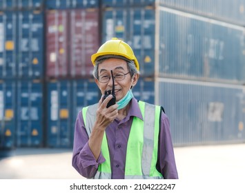 Senior Foreman Works At Shipping Container Yard Speaks With His Coworker Over Walkie Talkie. Logistics Supply Chain Management And International Import Export.