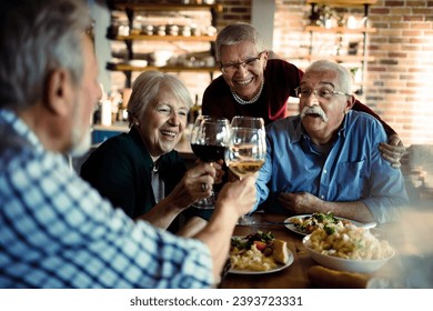 Senior Friends Enjoying a Meal and Wine Together - Powered by Shutterstock