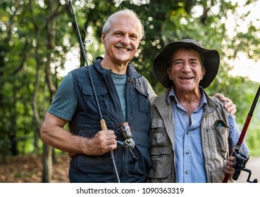 Senior Friends Fishing By The Lake