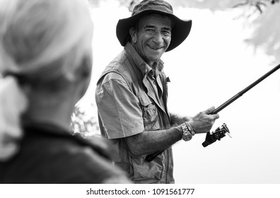 Senior Friends Fishing By The Lake