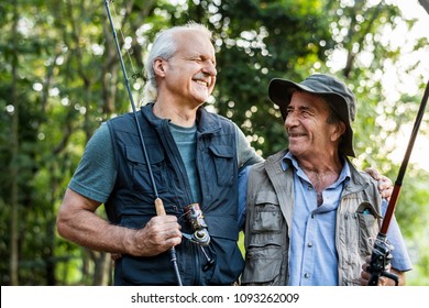 Senior Friends Fishing By The Lake