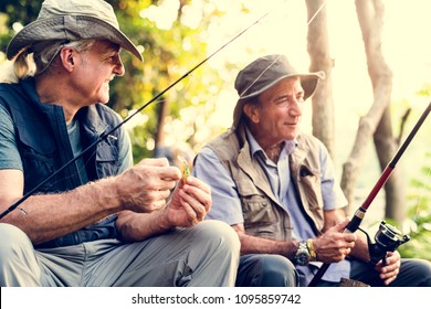 Senior Friends Fishing By The Lake