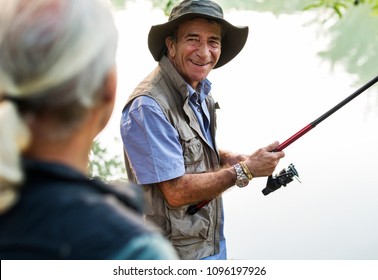 Senior Friends Fishing By The Lake