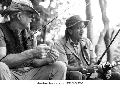 Senior Friends Fishing By The Lake