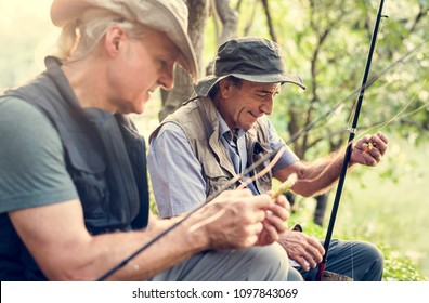 Senior Friends Fishing By The Lake