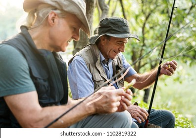 Senior Friends Fishing By The Lake