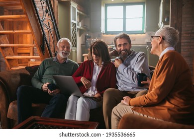 Senior friends using a laptop while relaxing in their lounge