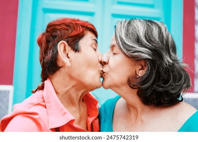 Senior gay couple kiss outside, Lesbian elderly couple of women having tender moment together, LGBTQ pride and elderly love relationships - Powered by Shutterstock