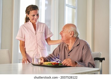 Senior gets lunch as meal on wheels served by woman from delivery service at home - Powered by Shutterstock