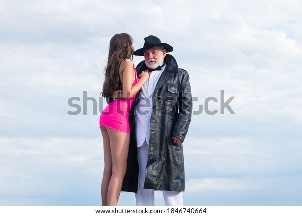 Senior glamour man and sexy young\
woman. Gangster look, Mafia pimp. Sexy lovers couple old and young.\
Dominant man. Mature dandy man with sexy girl.\
Submission