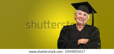 Senior Graduate Woman With Hands Folded On Coloured Background
