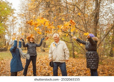 Senior grandma, mature muther and little child girl joyfully throwing autumn leaves at grandfather. Happy family having fun outdoor - Powered by Shutterstock