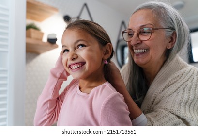 Senior grandmother and granddaughter standing indoors in bathroom, daily routine concept. - Powered by Shutterstock