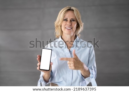 Senior Grandmother Showing Mobile Phone. Holding Smartphone