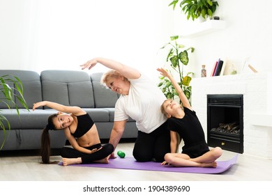 senior grandmother workout yoga withgranddaughters preschooler. They are sitting on mat at cozy home interior. Sport, parenthood and people concept - Powered by Shutterstock