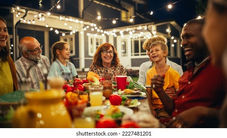 Senior Grandparent Sharing Interesting Childhood Memories to Her Diverse Relatives and Multiethnic Friends During an Outdoors Dinner Table with Smoked Barbecue Meat and Lots of Fresh Vegetables. - Powered by Shutterstock