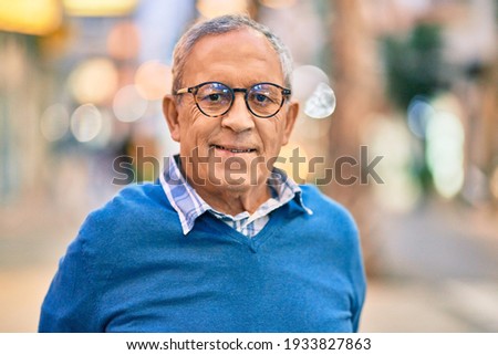 Senior grey-haired man smiling happy standing at the city.