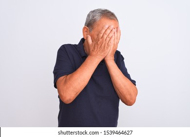 Senior Grey-haired Man Wearing Black Casual Polo Standing Over Isolated White Background With Sad Expression Covering Face With Hands While Crying. Depression Concept.