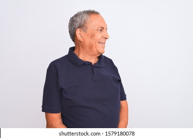 Senior Grey-haired Man Wearing Black Casual Polo Standing Over Isolated White Background Looking Away To Side With Smile On Face, Natural Expression. Laughing Confident.