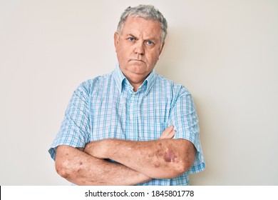 Senior grey-haired man wearing casual clothes skeptic and nervous, disapproving expression on face with crossed arms. negative person. 