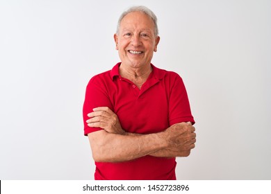 Senior grey-haired man wearing red polo standing over isolated white background happy face smiling with crossed arms looking at the camera. Positive person.