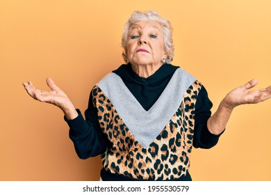 Senior grey-haired woman wearing sportswear clueless and confused with open arms, no idea and doubtful face.  - Powered by Shutterstock