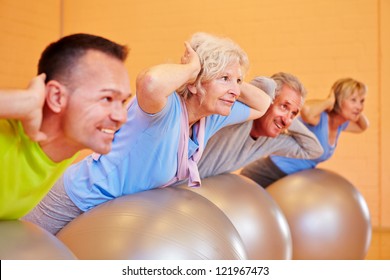 Senior Group In Back Training Class Exercising In Fitness Center