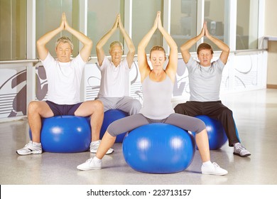 Senior group exercising in yoga class in gym - Powered by Shutterstock