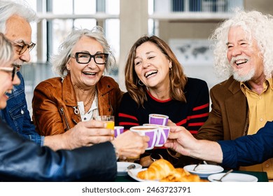 Senior group of retired people celebrating while having breakfast together at cafe bar. Mature friends enjoying free time drinking cappuccino at cafeteria terrace. Food and beverage concept. - Powered by Shutterstock