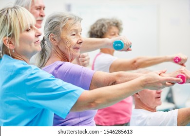 Senior Group Trains With Dumbbells For Health And Strength In Rehab