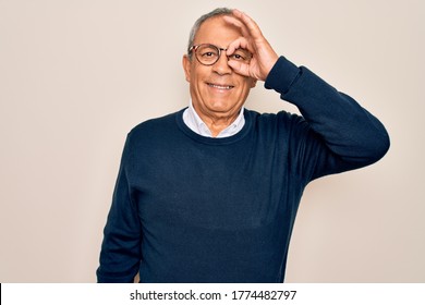 Senior Handsome Grey-haired Man Wearing Sweater And Glasses Over Isolated White Background Doing Ok Gesture With Hand Smiling, Eye Looking Through Fingers With Happy Face.