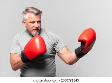 senior handsome man boxing against isolated wall - Powered by Shutterstock