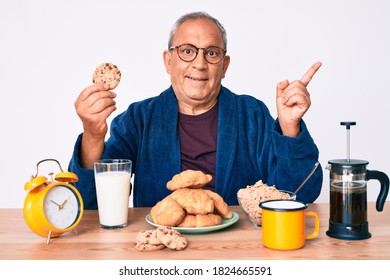 Senior Handsome Man With Gray Hair Sitting On The Table Eating Breakfast In The Morning Smiling Happy Pointing With Hand And Finger To The Side 