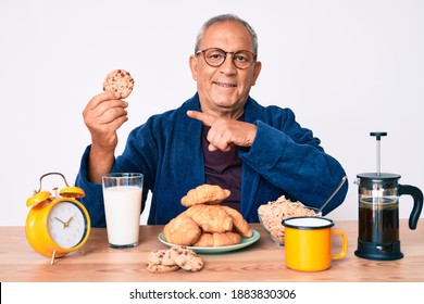 Senior Handsome Man With Gray Hair Sitting On The Table Eating Breakfast In The Morning Smiling Happy Pointing With Hand And Finger 