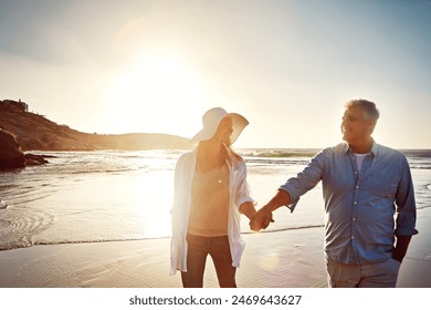 Senior, happy couple and holding hands with beach sunset for love, embrace or bonding in nature. Man, woman or lovers walking with smile on outdoor summer holiday by water or ocean coast in sunshine - Powered by Shutterstock