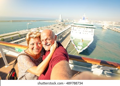 Senior happy couple taking selfie on ship on harbor background - Mediterranean cruise travel tour - Active elderly concept with retired people around the world - Bright sunny afternoon color tones