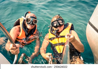 Senior Happy Couple Using Selfie Stick In Tropical Sea Excursion - Boat Trip Snorkeling In Exotic Scenarios - Concept Of Active Elderly And Fun Around The World - Soft Vintage Filtered Look