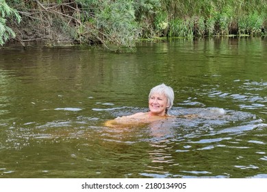 Senior Happy Smiling Woman Swimming In A River Or A Pond, Lake In The Countryside. Physical Health Concept