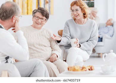 Senior happy women and older man gossiping at a tea party - Powered by Shutterstock