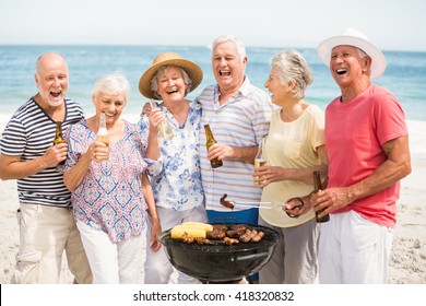 Senior having a barbecue on the beach on a sunny day - Powered by Shutterstock