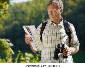 senior hiker holding map and binoculars. Copy space - Powered by Shutterstock